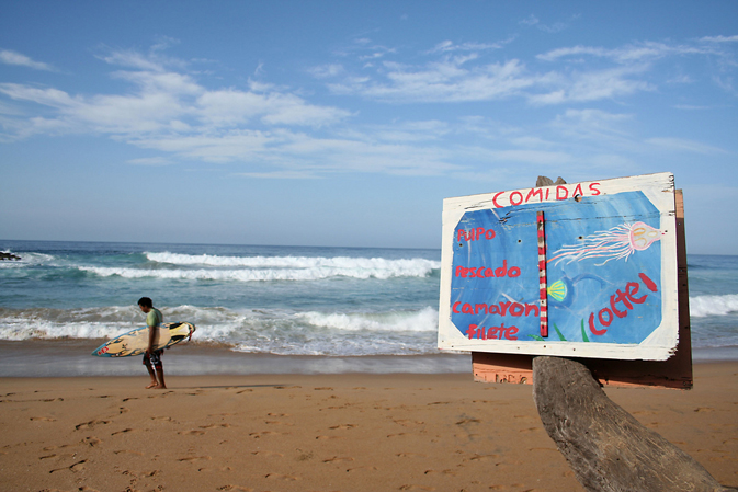 Surfer carrying his board at Zipolite Beach