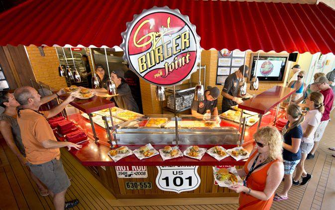 Guests aboard Carnival Breeze carry custom-made hamburgers and fries prepared at Guy’s Burger Joint, a free burger venue developed in partnership with Food Network personality Guy Fieri. Photo by Andy Newman/Carnival Cruise Lines