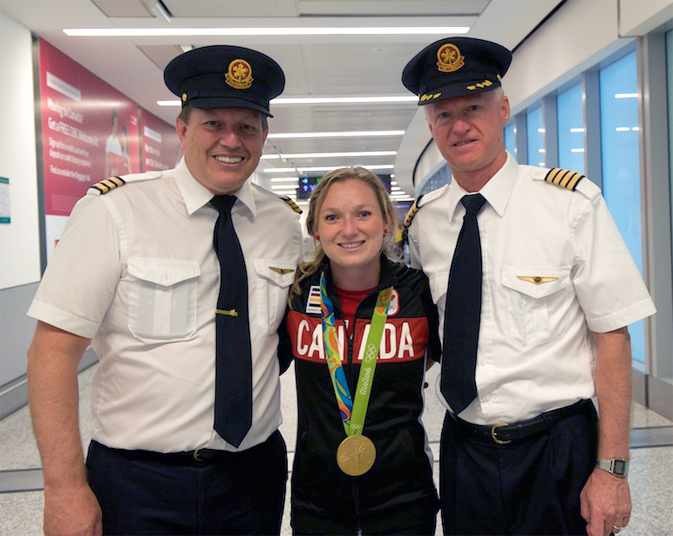 First Officer Brian Dietrich, trampoline champion Rosie MacLennan with her Gold medal, and Captain Steve Bulger