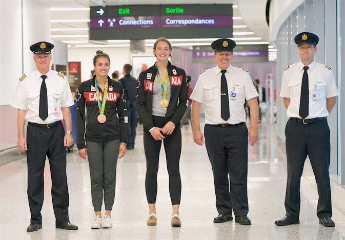 Olympic swimmers Kylie Masse (who won bronze in the Women's 4x100m freestyle relay), and multi-medal winner Penny Oleksiak with Air Canada crew