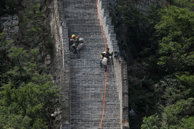 Workers carry their tools and belongings as they climb down the Jiankou section of the Great Wall, located in Huairou District, north of Beijing, China, June 7, 2017. REUTERS/Damir Sagolj