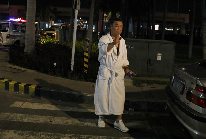 A tourist wearing a bathrobe gestures after he was evacuated from the Resorts World Manila after gunshots and explosions were heard in Pasay City, Metro Manila, Philippines June 2, 2017. REUTERS/Erik De Castro