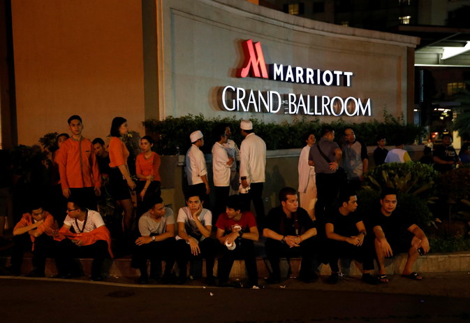 Evacuated employees are seen at the entrance of a hotel near a situation at a Resorts World building in Pasay City, Metro Manila, Philippines June 2, 2017. REUTERS/Erik De Castro