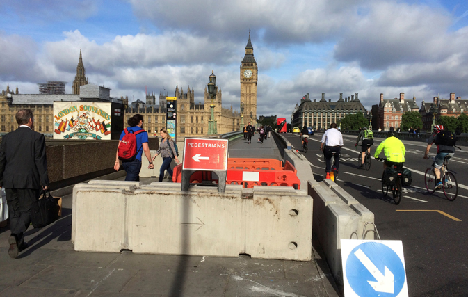 Pedestrians walk past newly erected barriers separating the road from the pavement on Westminster Bridge following an attack which left 7 people dead and dozens of injured in central London, Britain, June 5, 2017. REUTERS/Estelle Shirbon