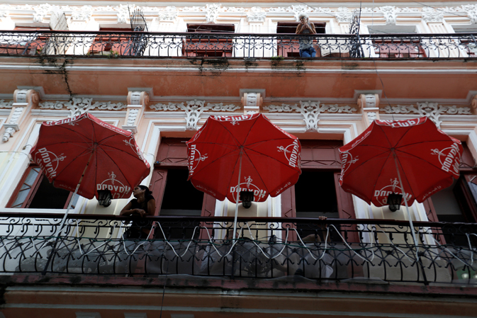 Women look out from balconies in Havana. 